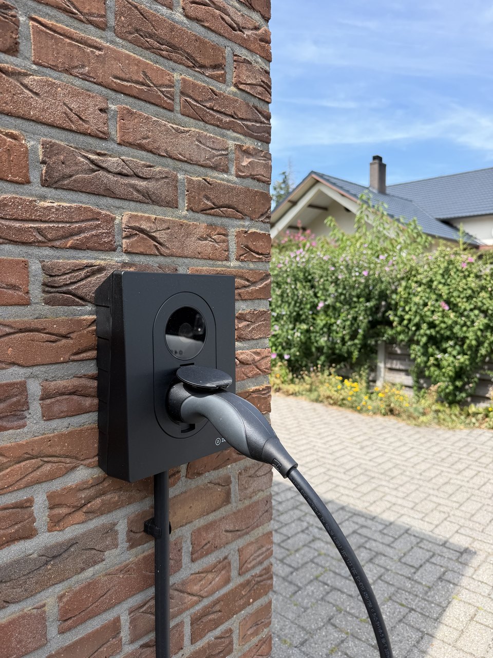 Zaptec laadpaal aan de gevel van een woning, tijdens het laden